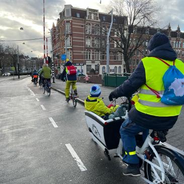 Ganze Familie im Lastenrad durch Amsterdam.