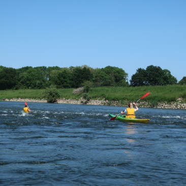 Mit dem Kanu durch die Stromschnelle.
