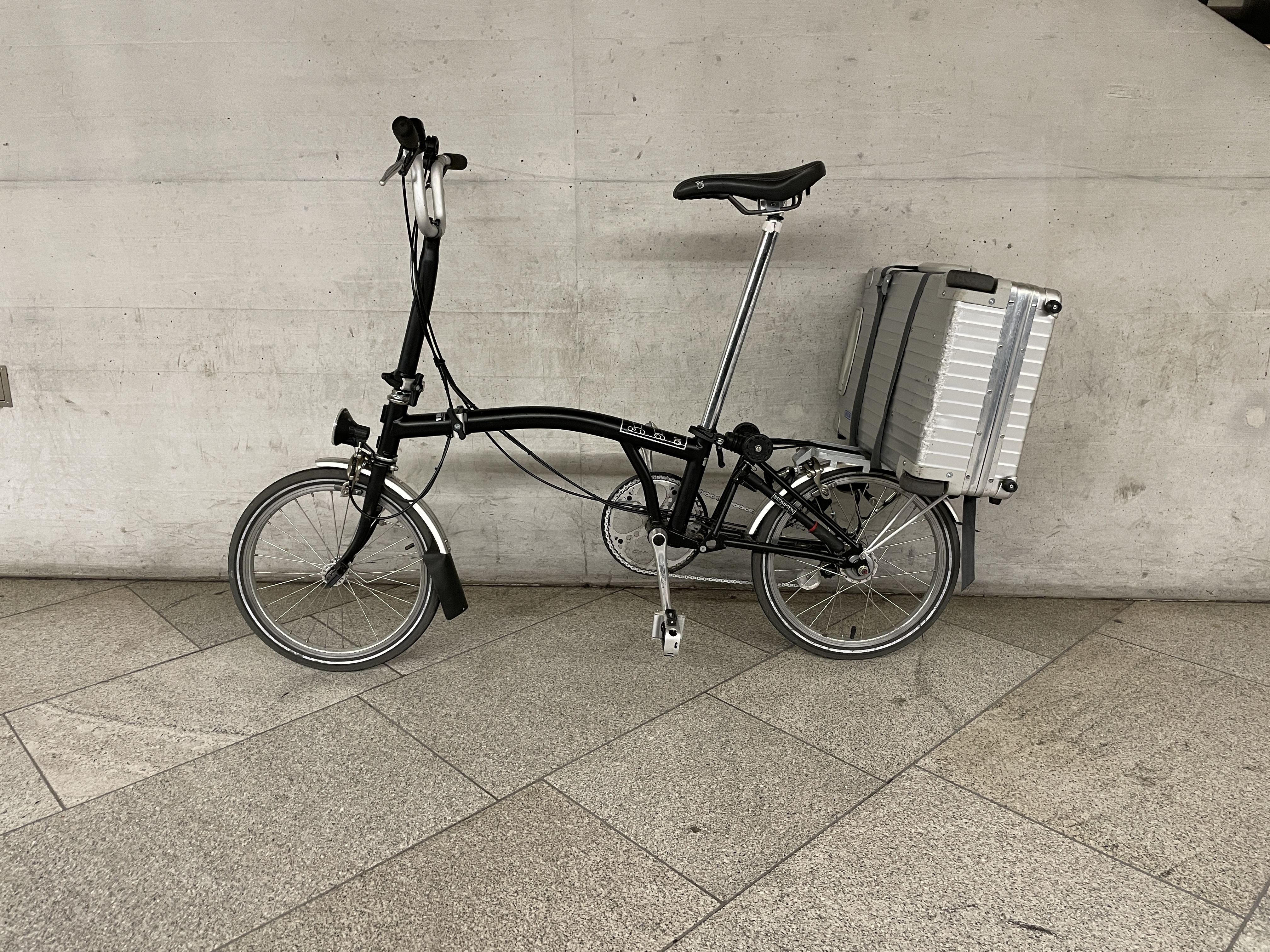 Perfekt für Wochenendeausflüge und Geschäftsreisen. Brompton mit Koffer.l