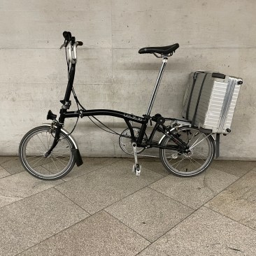 Perfekt für Wochenendeausflüge und Geschäftsreisen. Brompton mit Koffer.l